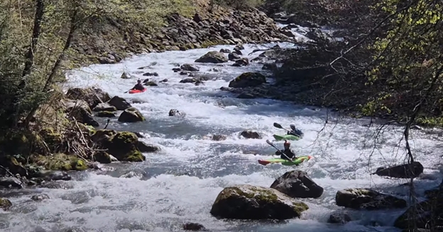 Drei Wildwasser-Fahrer befahren hintereinander die Dranse de Morzine 