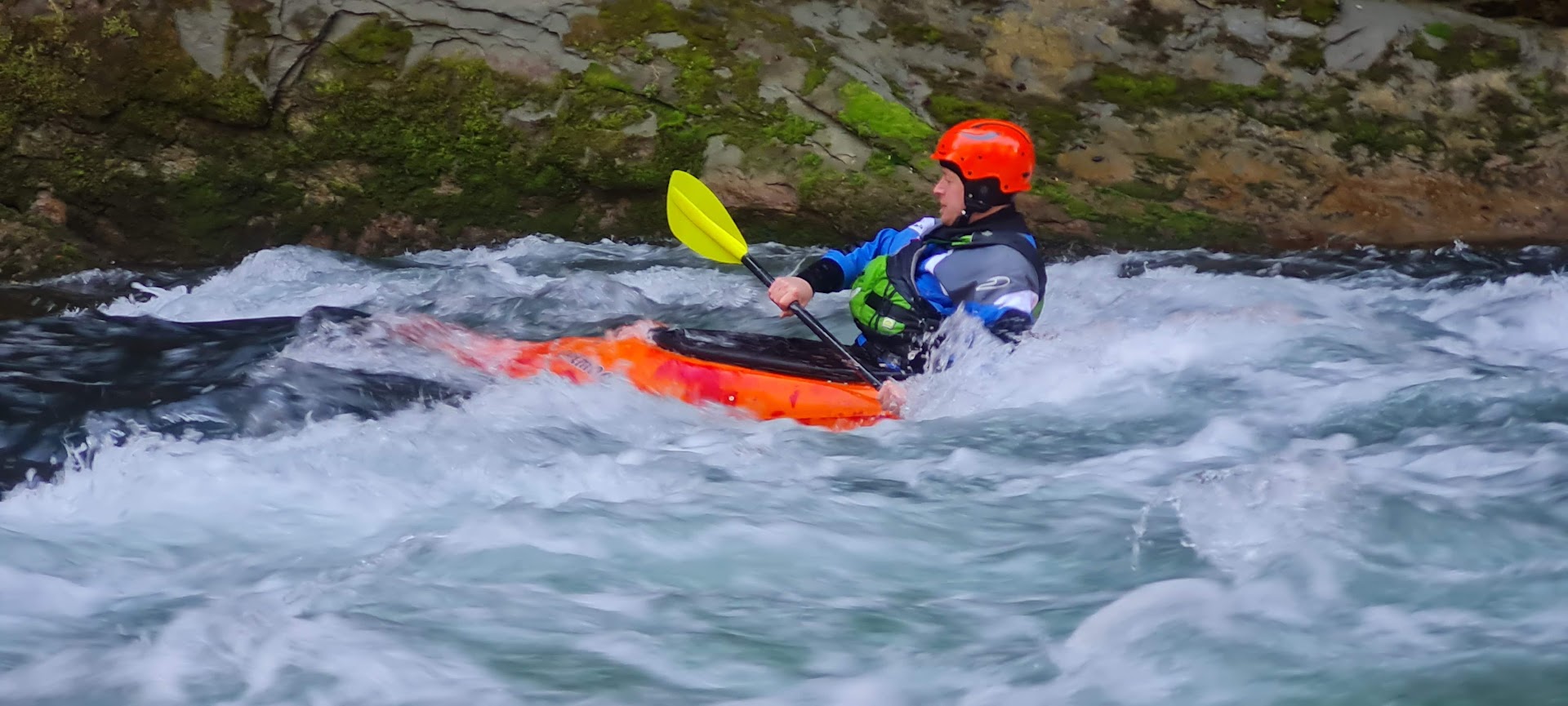 Der Kanute steuert mit seinem roten Boot sicher durch die Schwellen des Vorderrheins.
